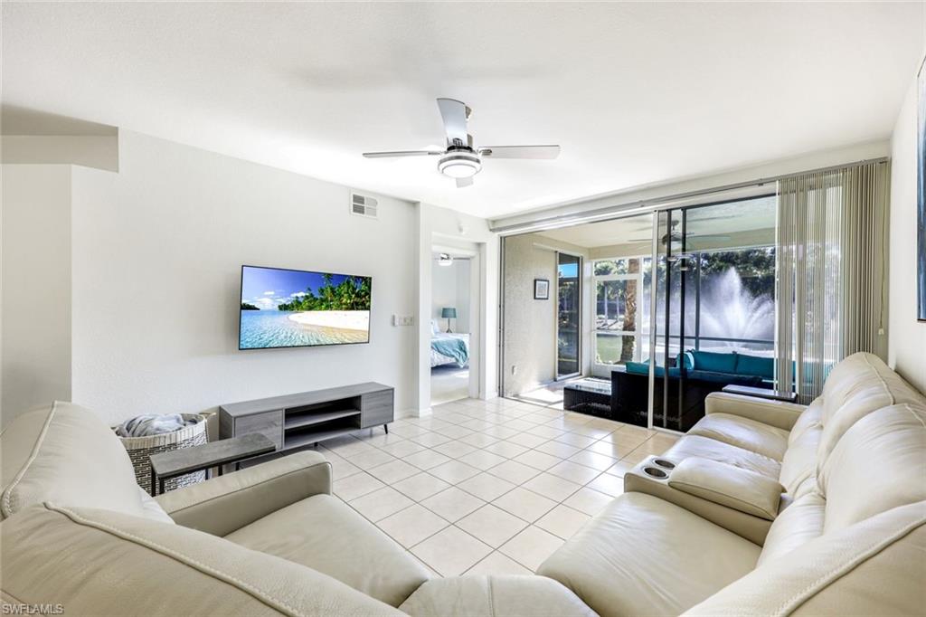 10921 Santa Margherita Road, Unit 103 Estero, FL 34135 - Photo 4 of 38 a living room with furniture and a flat screen tv