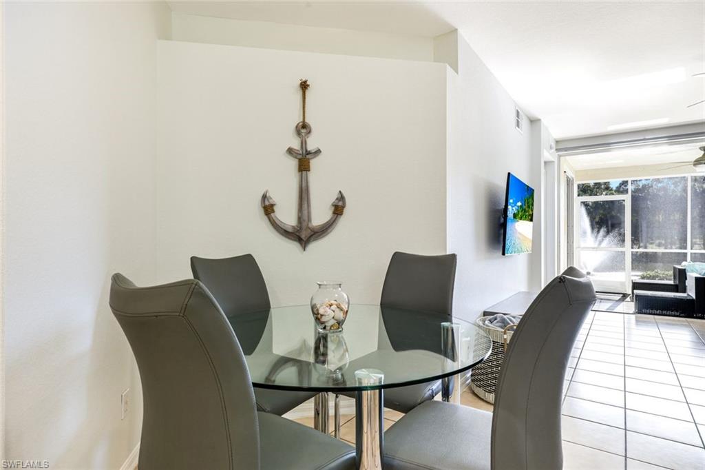 10921 Santa Margherita Road, Unit 103 Estero, FL 34135 - Photo 9 of 38 a view of a dining room with furniture and wooden floor