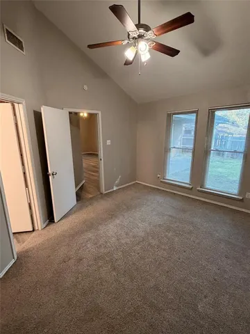 an empty room with windows and fan