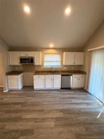 a large kitchen with stainless steel appliances granite countertop a stove and a sink