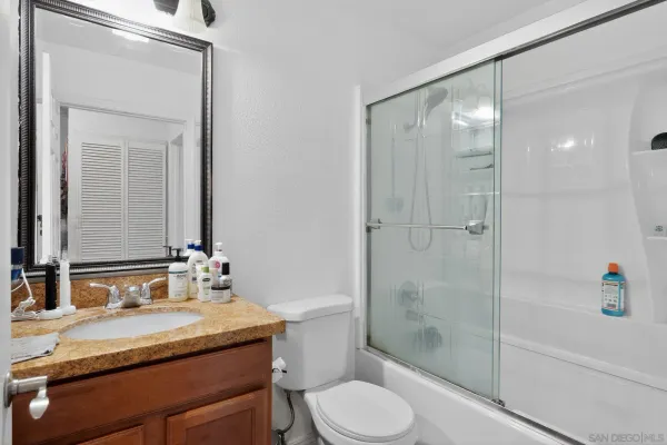 a bathroom with a granite countertop sink toilet and shower