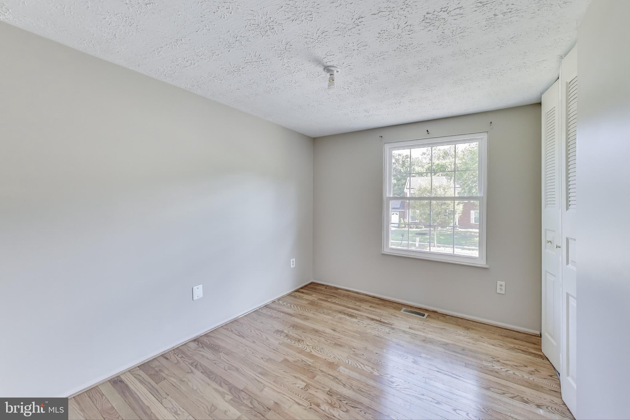 9217 Briarchip Street Laurel, MD 20708 - Photo 22 of 45 an empty room with wooden floor and windows