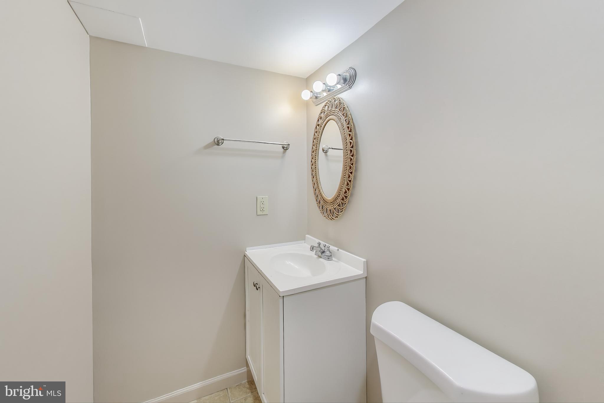 9217 Briarchip Street Laurel, MD 20708 - Photo 28 of 45 a bathroom with a toilet a sink and mirror