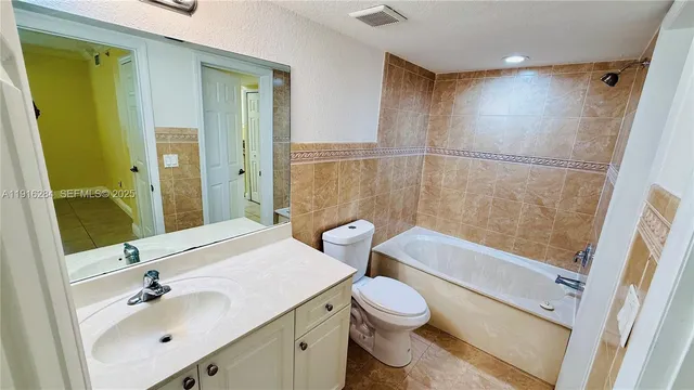 a bathroom with a sink mirror toilet and bathtub
