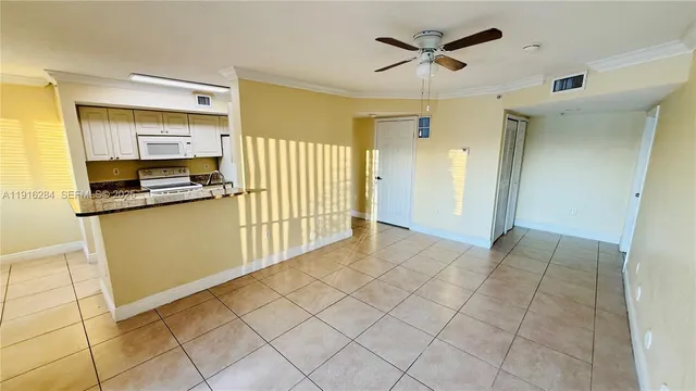 a view of a kitchen with wooden cabinets and a stove top oven