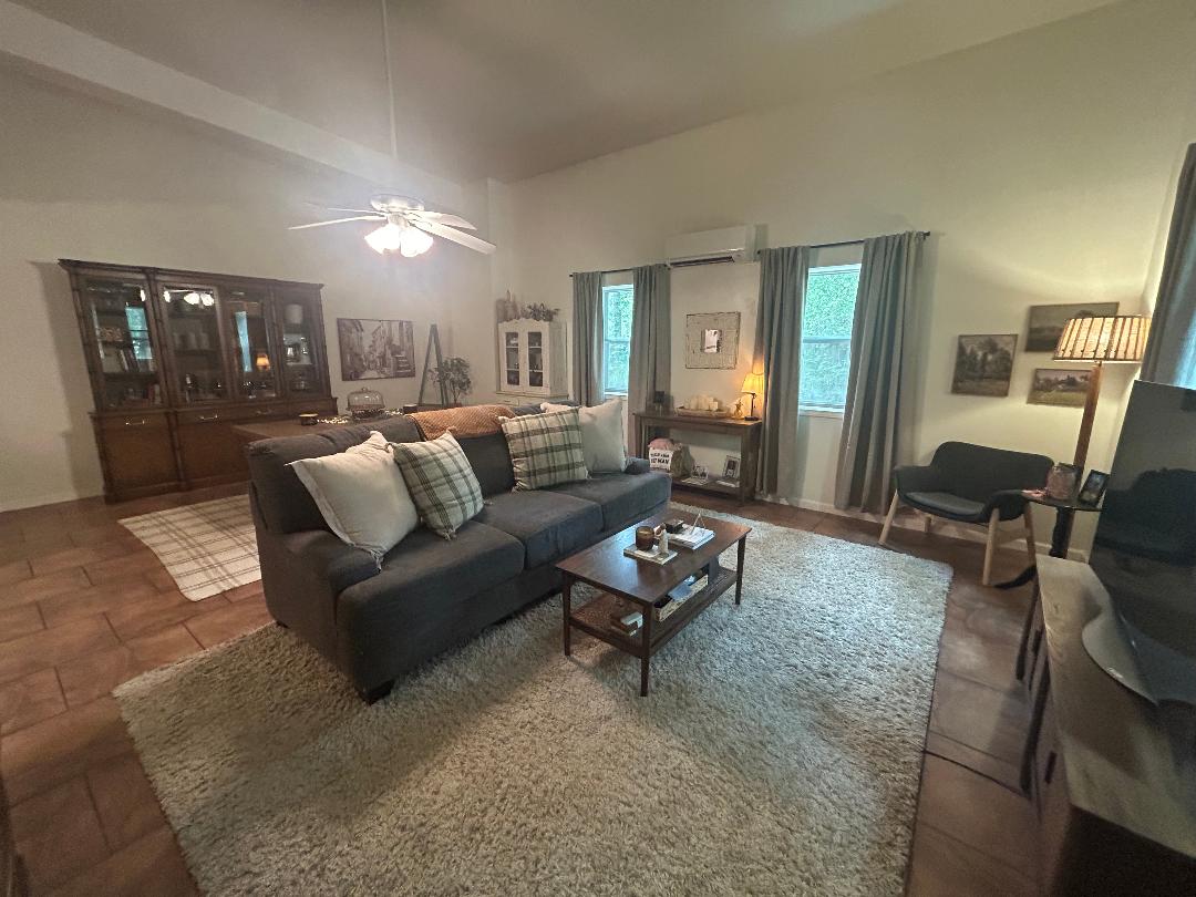 111 Post Oak Lane Elgin, TX 78621 - Photo 28 of 39 Living room featuring lofted ceiling, ceiling fan, and a mini split for heating / cooling