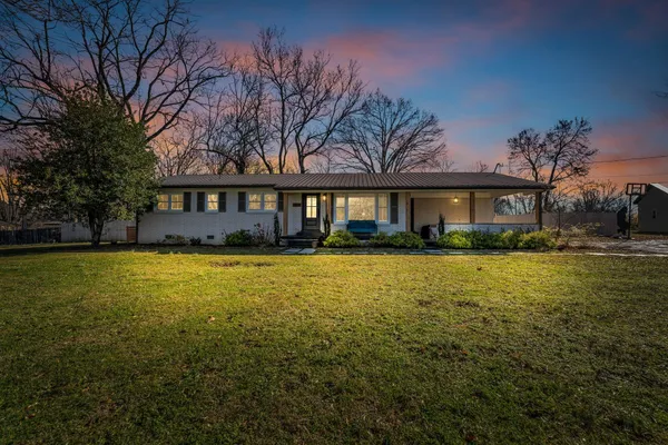 a front view of a house with swimming pool and green space