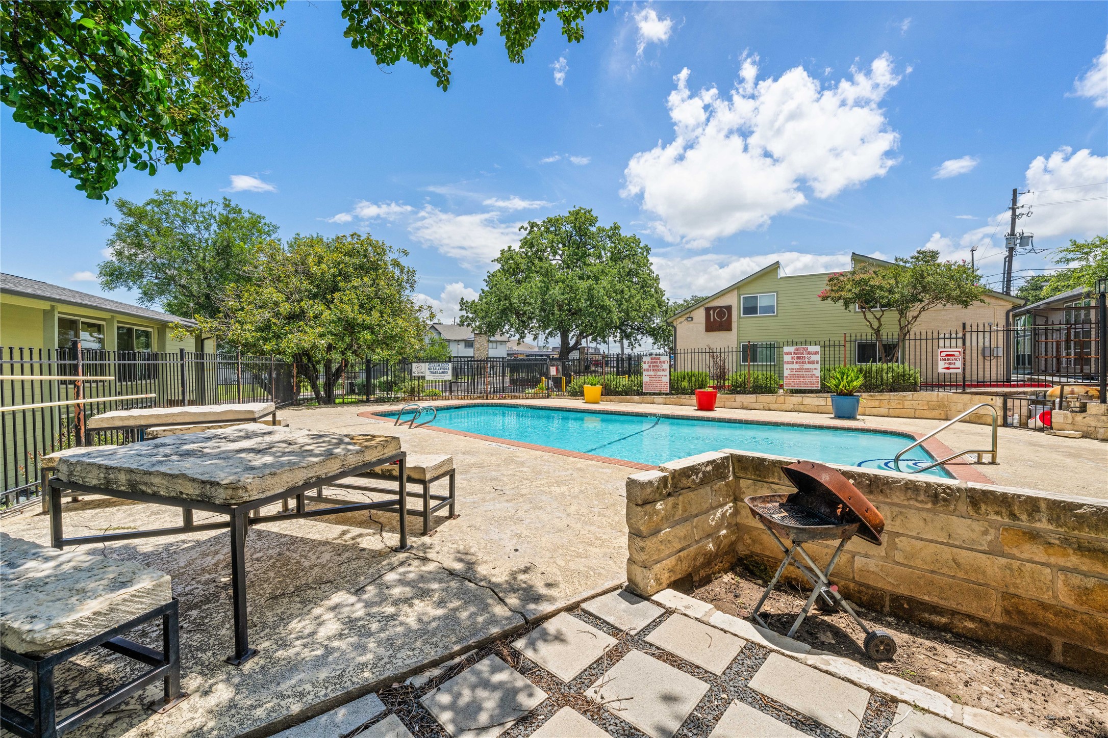 2124 Burton Drive, Unit 159 Austin, TX 78741 - Photo 20 of 23 An inviting pool area with ample seating and barbecue space, perfect for outdoor entertaining.