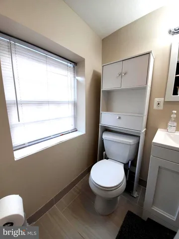a living room with furniture a large window and a refrigerator