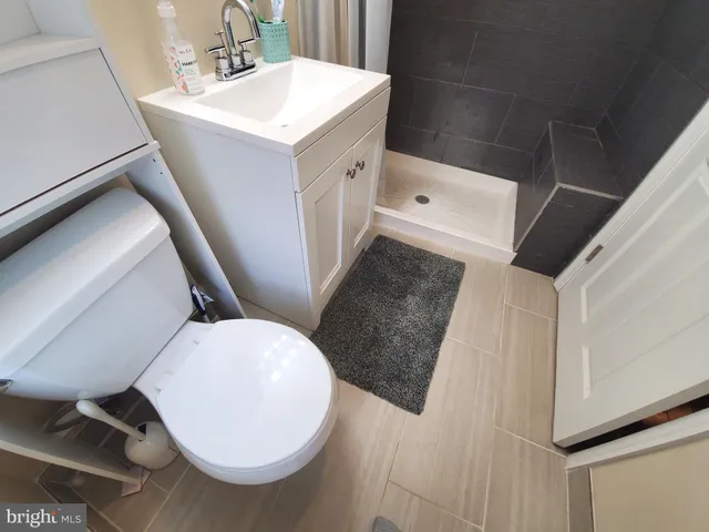 a large kitchen with kitchen island granite countertop a stove top oven a sink a counter space and cabinets