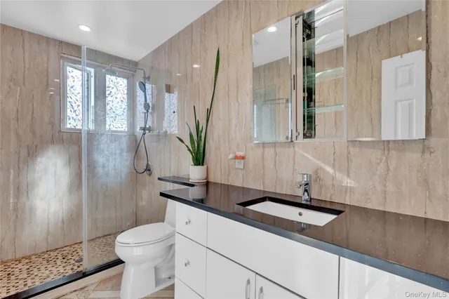 a bathroom with a sink a toilet and shower