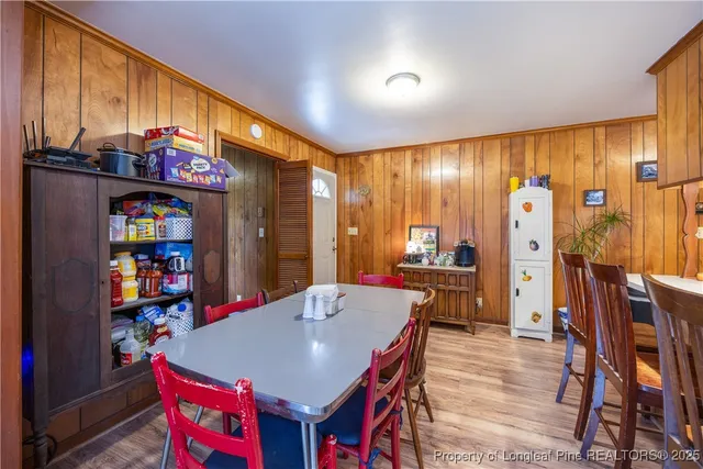 a large kitchen with stainless steel appliances a dining table and chairs with the wooden floor