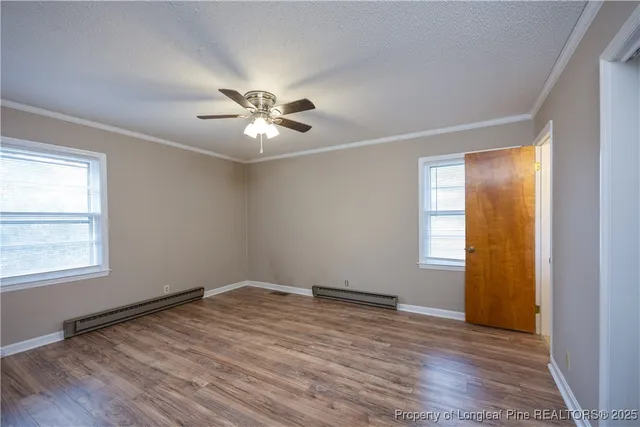a view of empty room with wooden floor