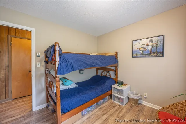 a bedroom with a bed and wooden floor