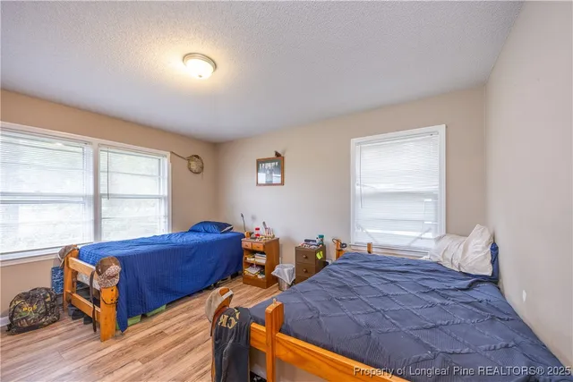 a bedroom with two beds and a large window