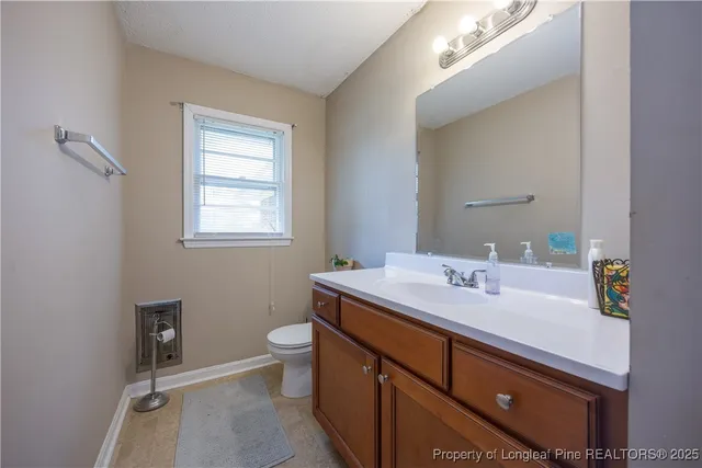 a bathroom with a sink toilet and window