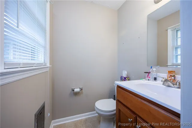 a bathroom with a sink toilet and a window