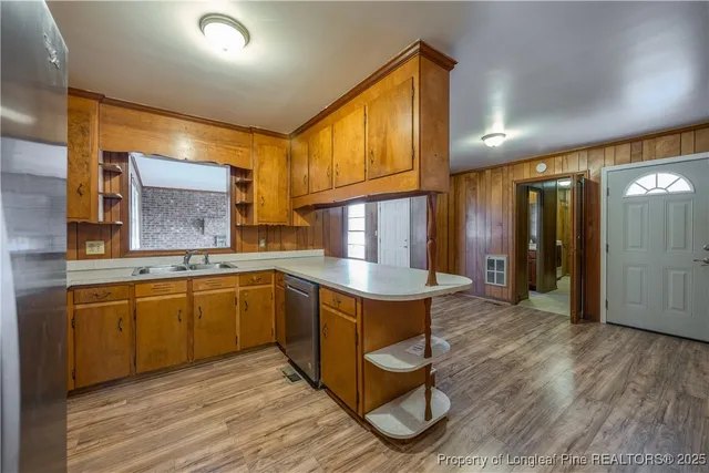a kitchen with stainless steel appliances granite countertop a sink a stove and wooden floors
