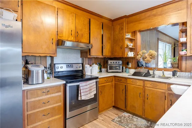 a kitchen with stainless steel appliances granite countertop a stove a sink and a microwave