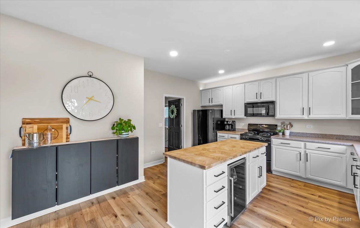985 Kendall Street Elburn, IL 60119 - Photo 2 of 32 a kitchen with cabinets and wooden floor