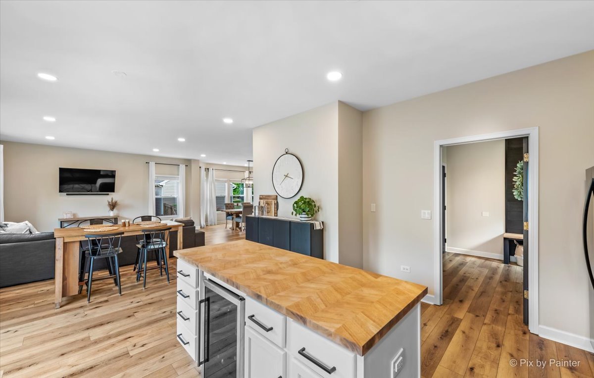 985 Kendall Street Elburn, IL 60119 - Photo 28 of 32 a room with kitchen island a dining table wooden floor and a view of living room
