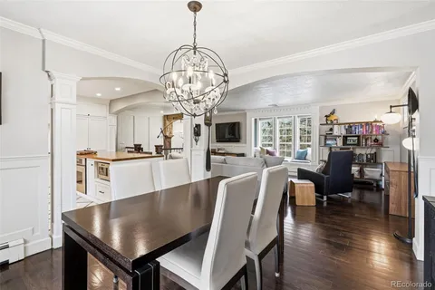 a view of a dining room with furniture a chandelier and wooden floor