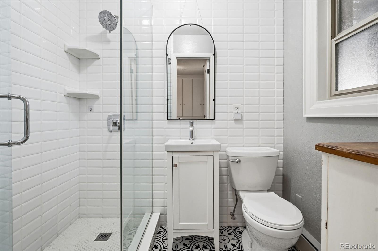 3393 Simms Street Wheat Ridge, CO 80033 - Photo 18 of 42 a bathroom with a toilet sink and shower