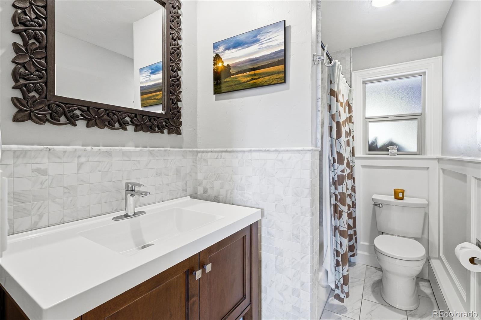 3393 Simms Street Wheat Ridge, CO 80033 - Photo 24 of 42 a bathroom with a sink mirror vanity and toilet