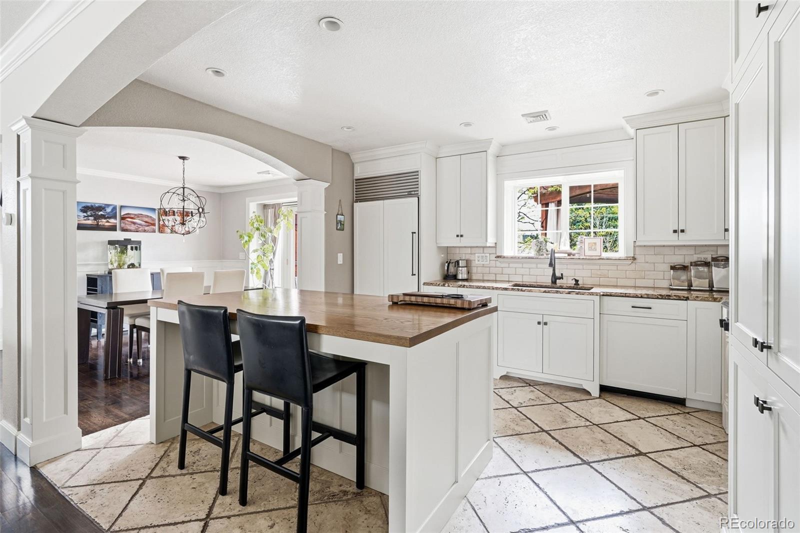 3393 Simms Street Wheat Ridge, CO 80033 - Photo 9 of 42 a kitchen with stainless steel appliances kitchen island granite countertop a sink and cabinets