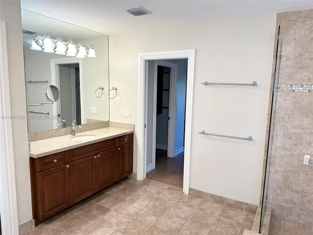 a spacious bathroom with a double vanity sink and a mirror