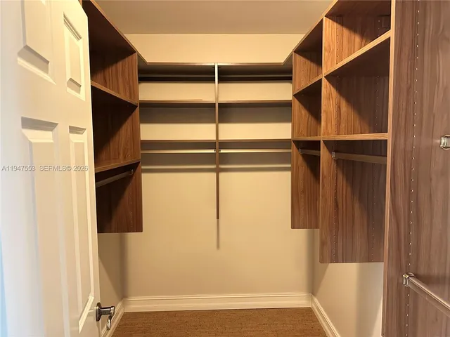 a view of walk in closet with empty racks