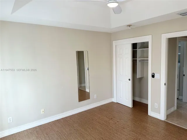 an empty room with wooden floor and window