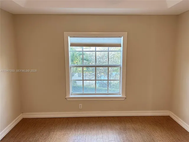 a view of a small space with wooden floor and a window