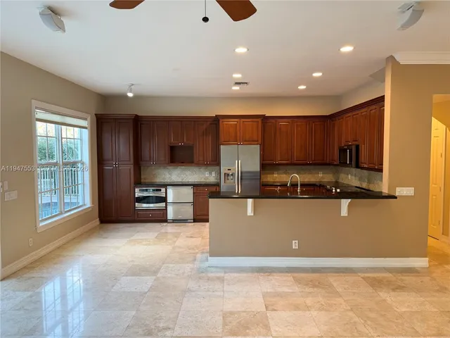 a large kitchen with stainless steel appliances granite countertop a large counter top and a stove top oven