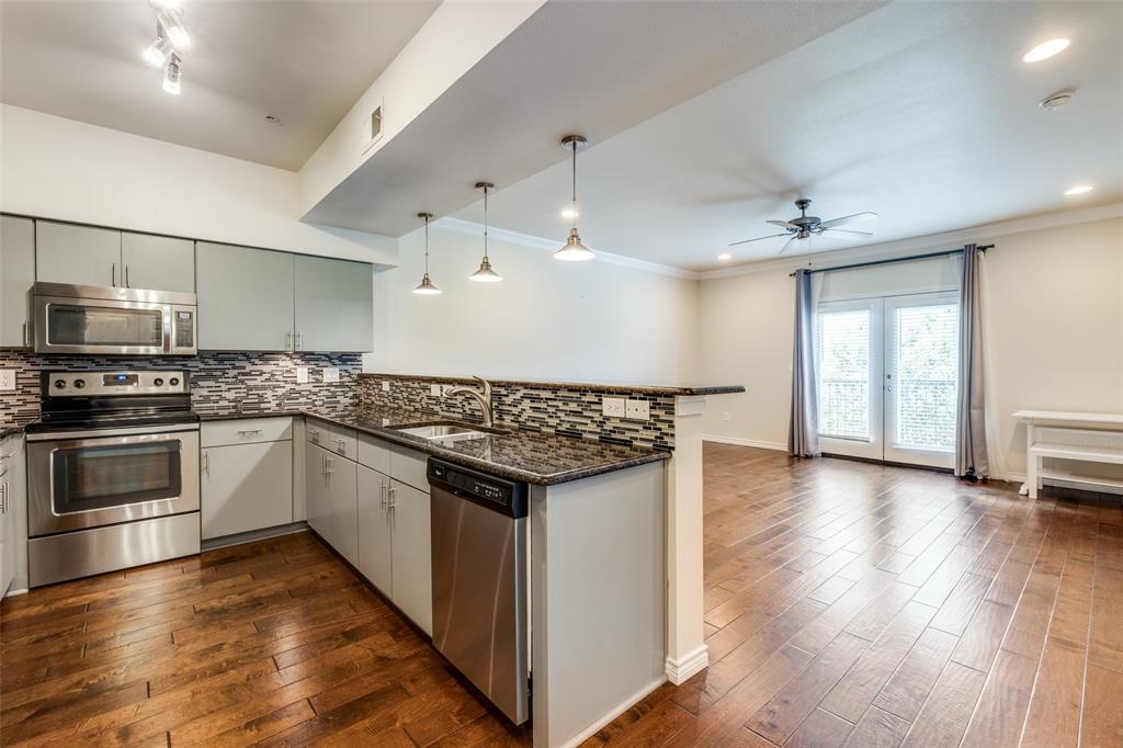 a kitchen with stainless steel appliances granite countertop a stove and a wooden floors