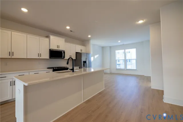 a kitchen with stainless steel appliances a microwave a sink a stove a microwave and cabinets