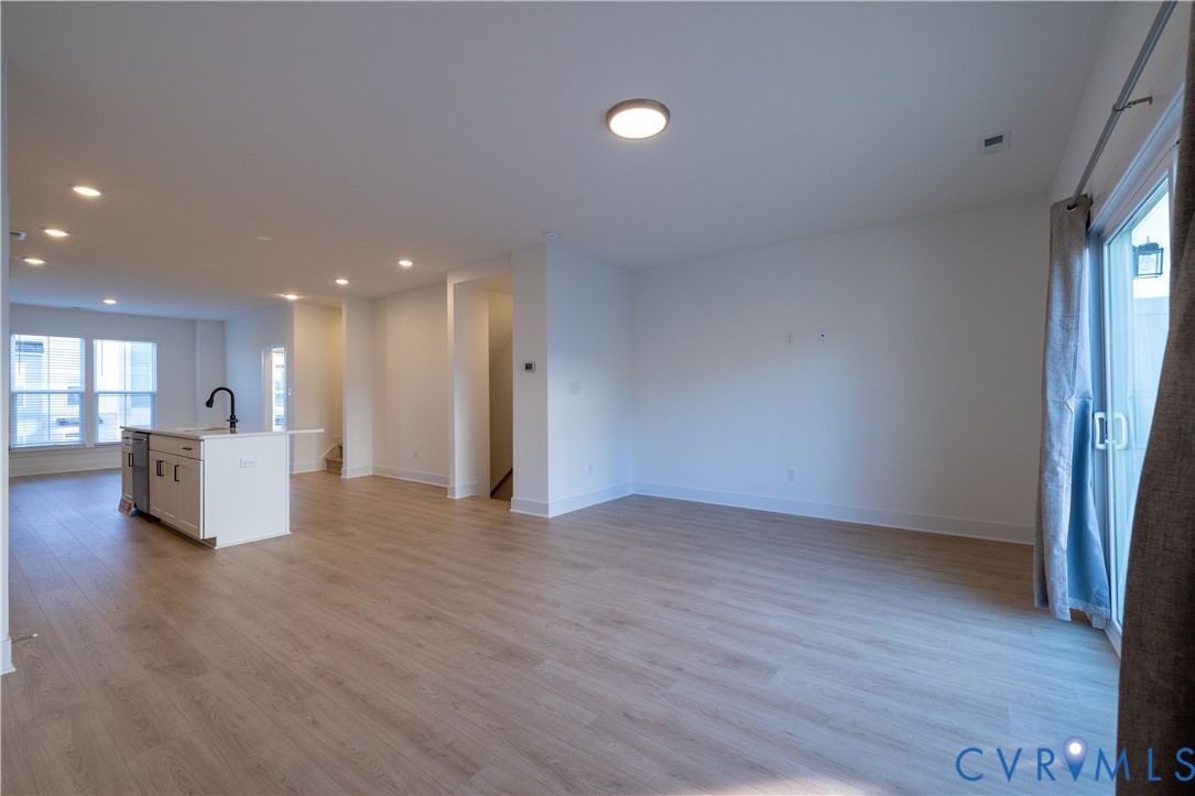 15309 Sunray Alley Chesterfield, VA 23832 - Photo 21 of 50 a view of an empty room with wooden floor and a kitchen