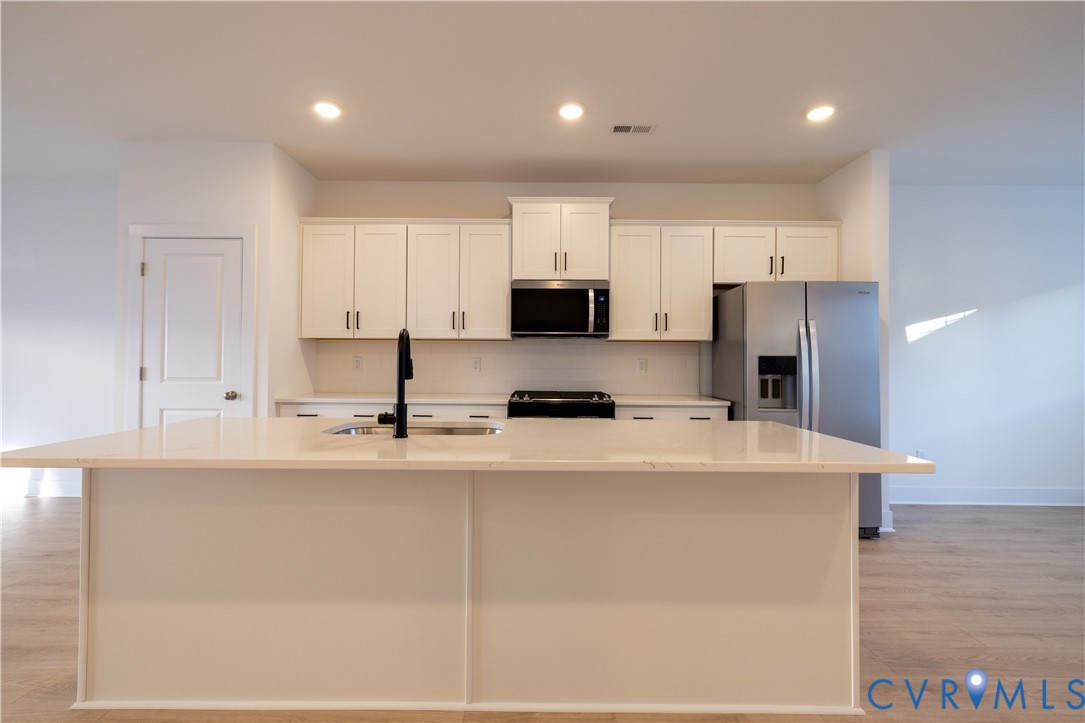 15309 Sunray Alley Chesterfield, VA 23832 - Photo 23 of 50 a kitchen with stainless steel appliances a refrigerator a stove top oven a sink and white cabinets