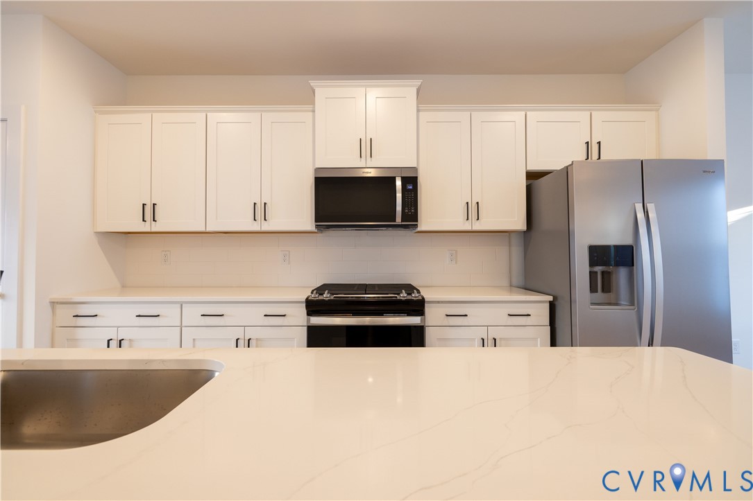 15309 Sunray Alley Chesterfield, VA 23832 - Photo 24 of 50 a kitchen with stainless steel appliances a stove a refrigerator a sink a microwave and cabinets