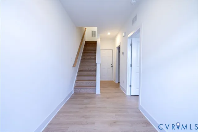 a view of a hallway with wooden floor