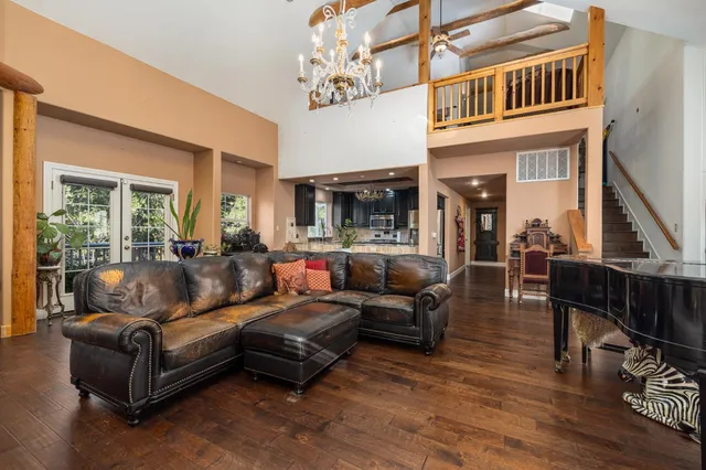 a living room with furniture a flat screen tv and kitchen view