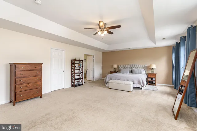 a spacious bedroom with a bed and a ceiling fan