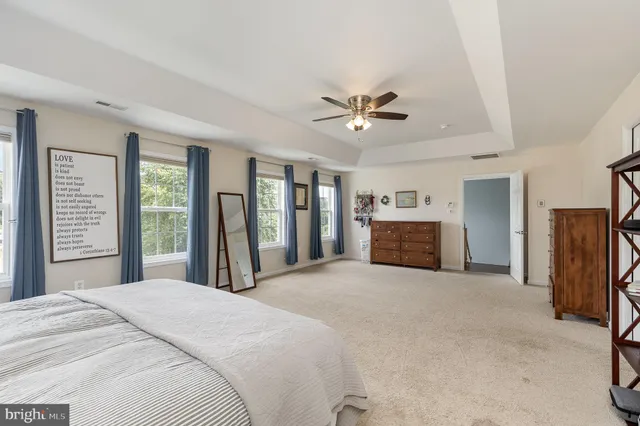 a large bed sitting in a spacious bedroom next to a window