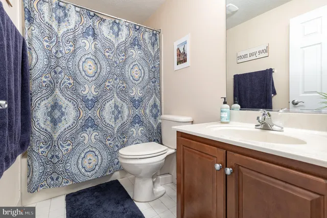 a bathroom with a granite countertop toilet sink and mirror