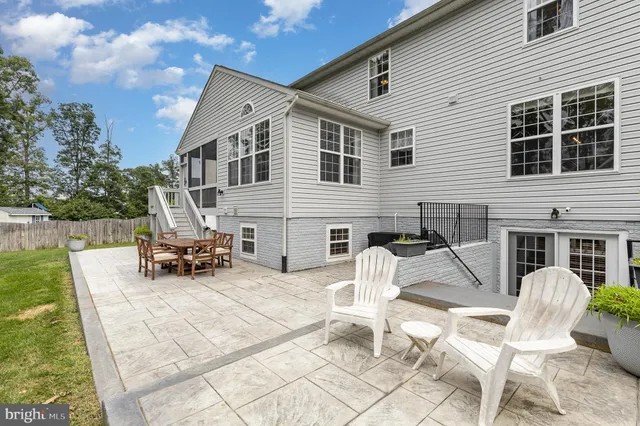 a view of a white house with a patio table and chairs