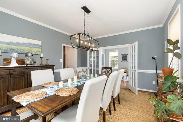 a dining room with furniture a chandelier and wooden floor