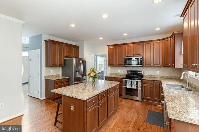 a kitchen with stainless steel appliances granite countertop counter space cabinets a sink and a refrigerator