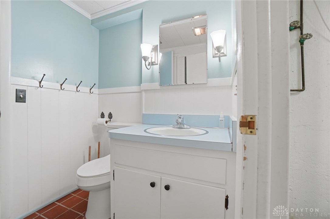 6119 Flemington Road Dayton, OH 45459 - Photo 53 of 76 This bright bathroom features a vanity, toilet, and charming wall paneling.