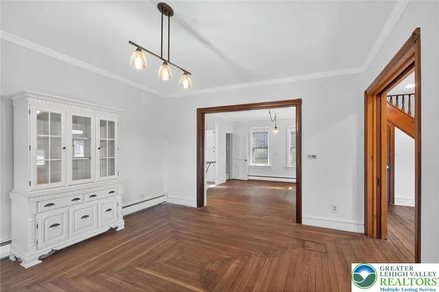 a kitchen with stainless steel appliances granite countertop a stove a sink dishwasher a refrigerator and white cabinets with wooden floor