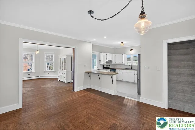 a kitchen with granite countertop white cabinets white appliances and a sink